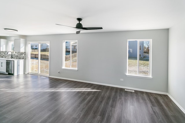 unfurnished living room featuring ceiling fan, dark wood-type flooring, and sink