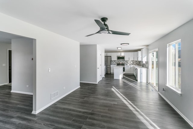 unfurnished living room with ceiling fan, dark wood-type flooring, and sink