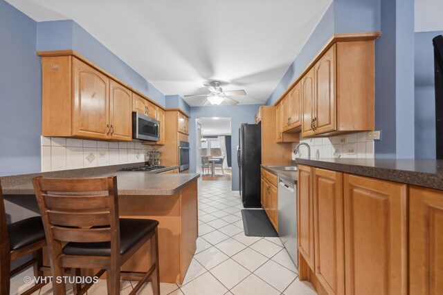 kitchen featuring sink, stainless steel appliances, backsplash, kitchen peninsula, and light tile patterned flooring