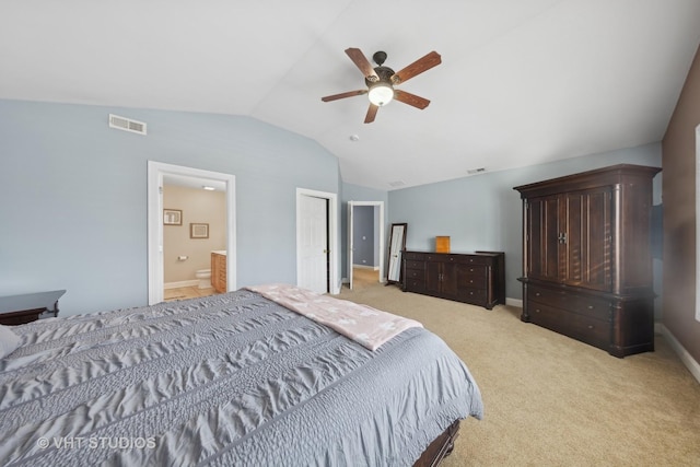 bedroom featuring ensuite bathroom, ceiling fan, light carpet, and vaulted ceiling