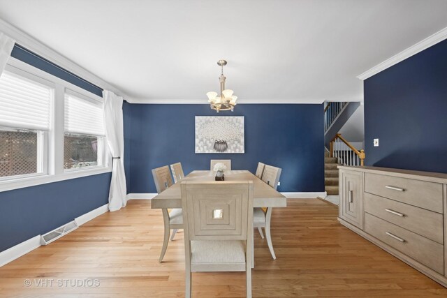 living room with a chandelier, hardwood / wood-style floors, and crown molding