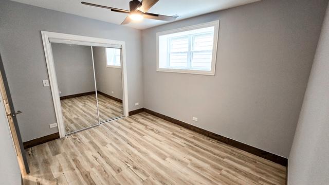 unfurnished bedroom featuring light wood-type flooring, ceiling fan, and a closet