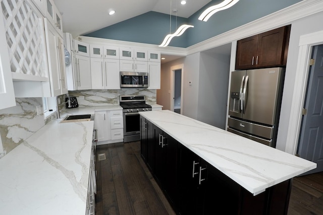 kitchen with a center island, decorative light fixtures, stainless steel appliances, decorative backsplash, and lofted ceiling