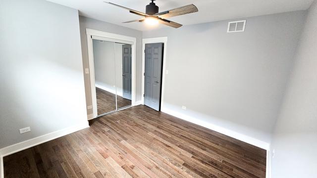 unfurnished bedroom with wood-type flooring, ceiling fan, and a closet