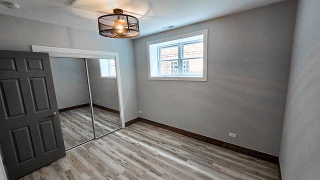 unfurnished bedroom featuring light hardwood / wood-style floors and a closet