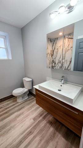 bathroom featuring toilet, vanity, and hardwood / wood-style flooring