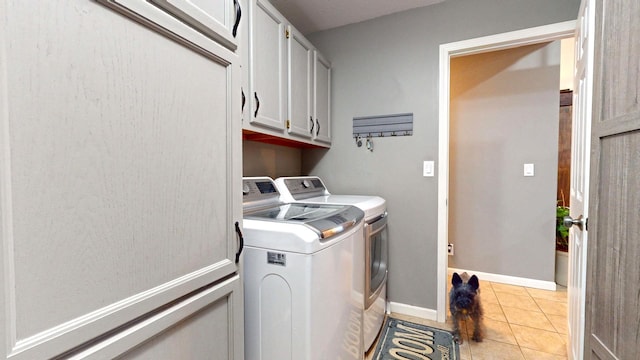 laundry area featuring cabinets, independent washer and dryer, and light tile patterned flooring