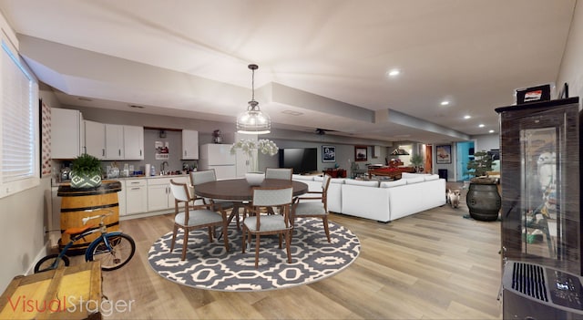 dining space featuring light hardwood / wood-style flooring, ceiling fan, and sink