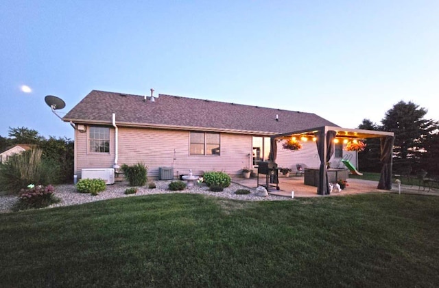 back of property with a lawn, cooling unit, and a patio area