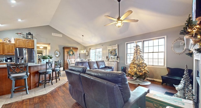 living room with hardwood / wood-style floors, ceiling fan, and lofted ceiling