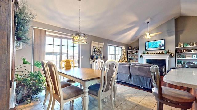 tiled dining room featuring ceiling fan with notable chandelier and lofted ceiling