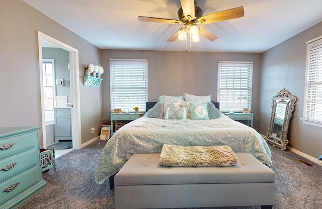 bedroom featuring dark colored carpet, ensuite bath, and ceiling fan