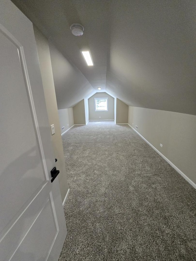 bonus room with carpet floors and vaulted ceiling