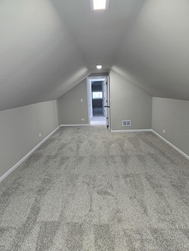 additional living space featuring carpet floors and vaulted ceiling