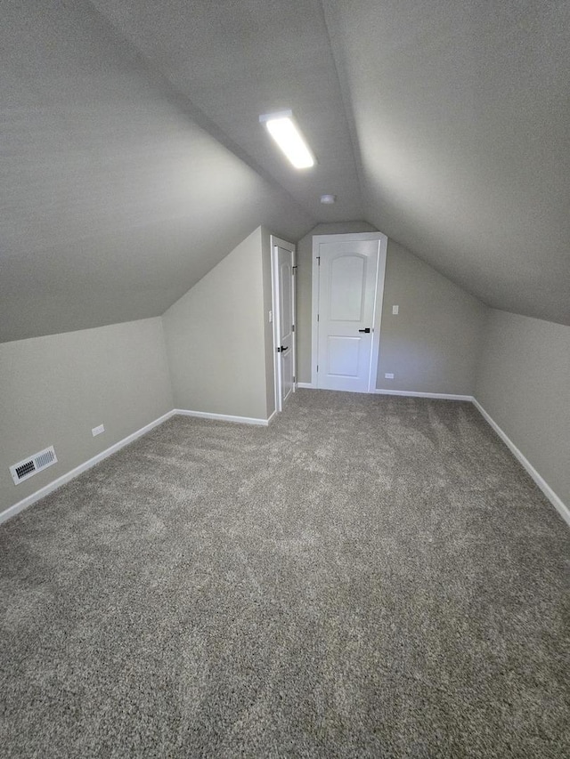 bonus room with a textured ceiling, carpet floors, and lofted ceiling