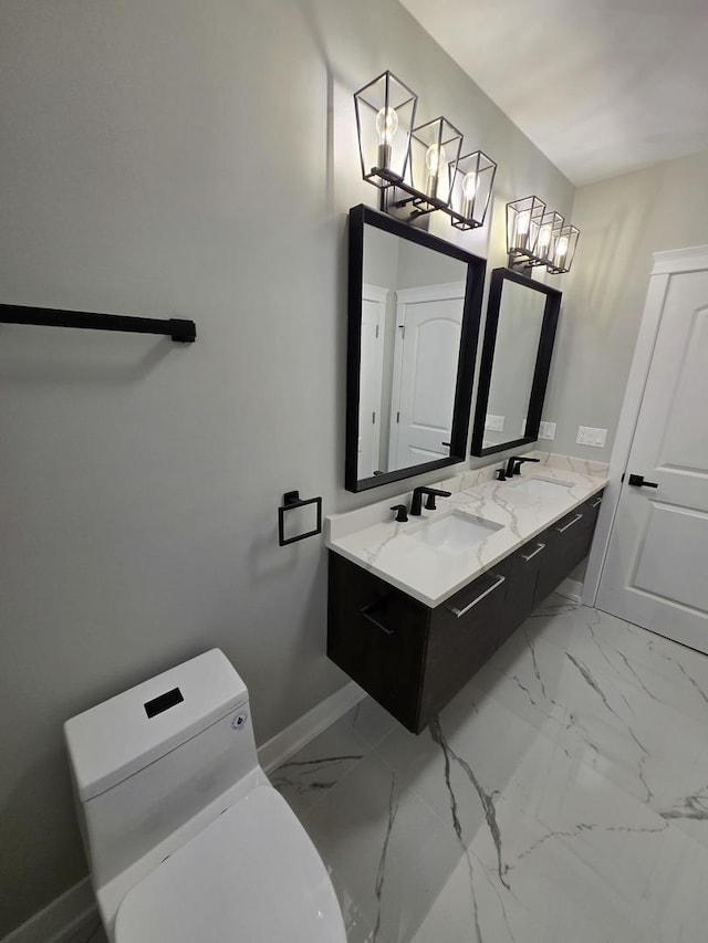 bathroom featuring a chandelier, vanity, and toilet