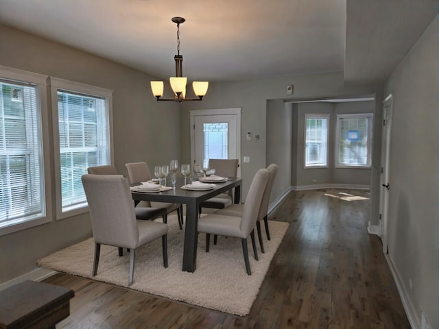 dining room with a notable chandelier, dark hardwood / wood-style floors, and a healthy amount of sunlight