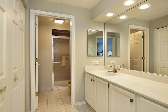 bathroom featuring tile patterned floors, vanity, toilet, and walk in shower