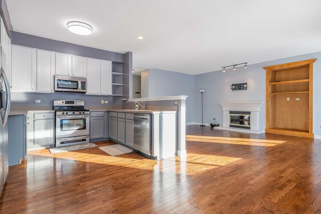 kitchen with gray cabinetry, sink, light wood-type flooring, and appliances with stainless steel finishes