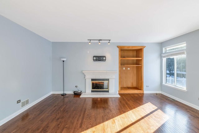 unfurnished living room with dark wood-type flooring and built in features