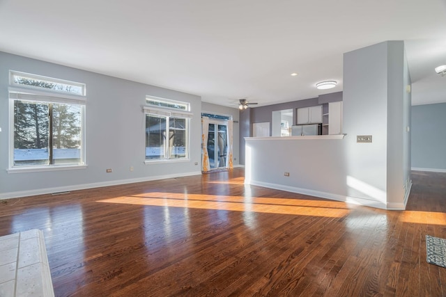 unfurnished living room with ceiling fan and wood-type flooring