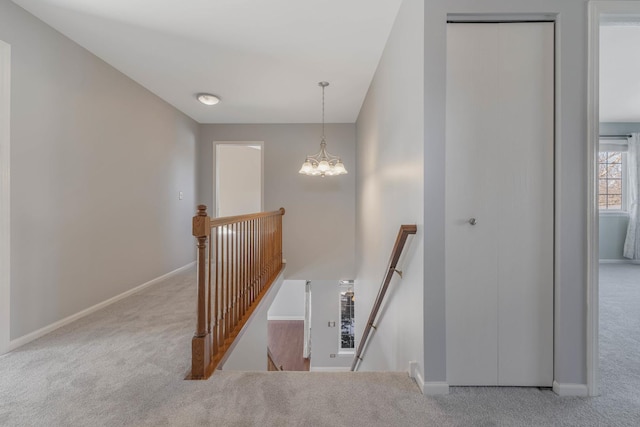 staircase with carpet floors and a chandelier