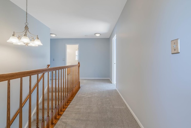 corridor with carpet floors and a notable chandelier