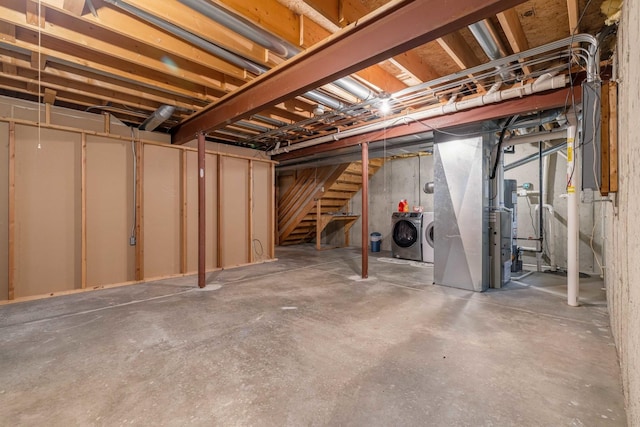 basement featuring washing machine and dryer and heating unit