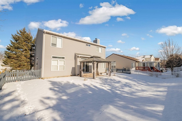 snow covered rear of property featuring a gazebo