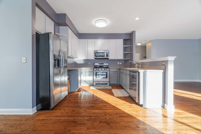 kitchen with appliances with stainless steel finishes, sink, light hardwood / wood-style flooring, and gray cabinetry