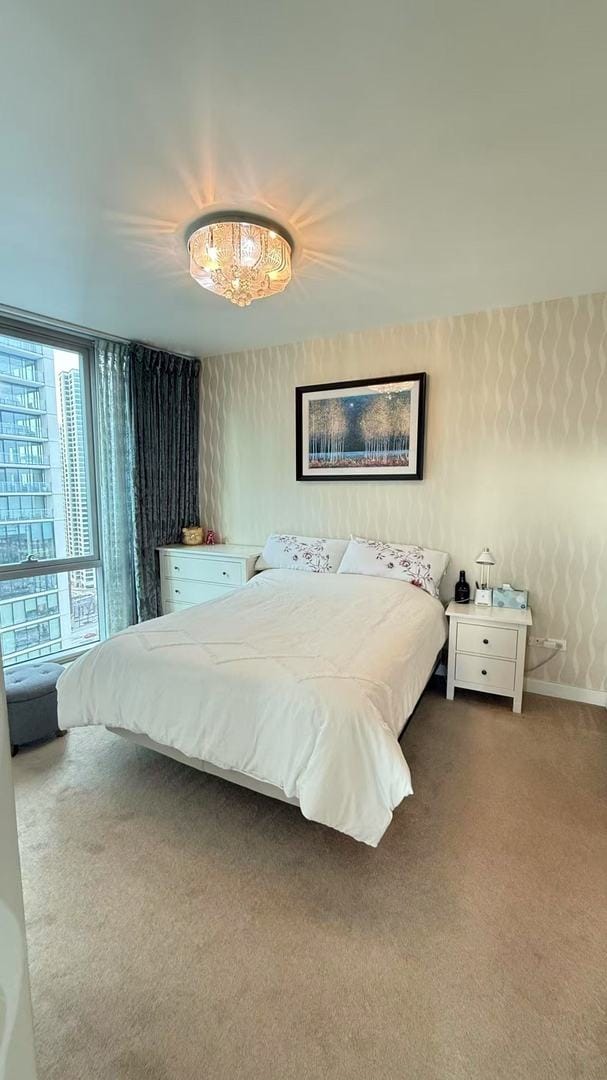 bedroom featuring carpet floors and a wall of windows