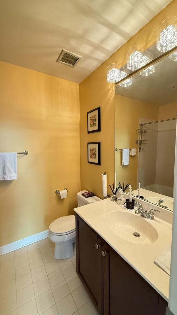 bathroom with walk in shower, tile patterned flooring, vanity, and toilet