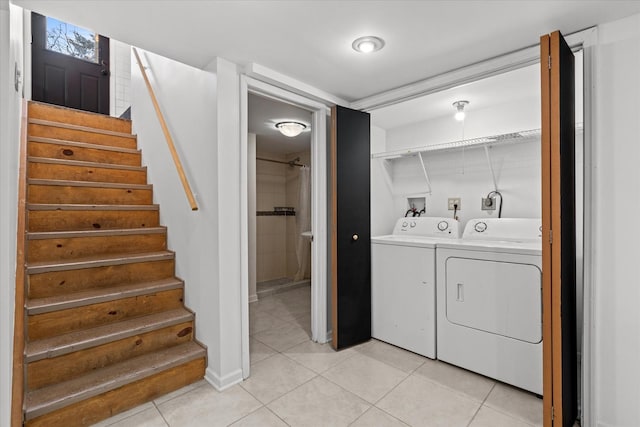 clothes washing area featuring light tile patterned floors and washing machine and clothes dryer