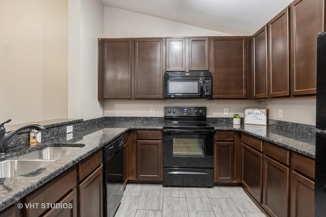 kitchen with lofted ceiling, black appliances, sink, dark stone countertops, and dark brown cabinetry