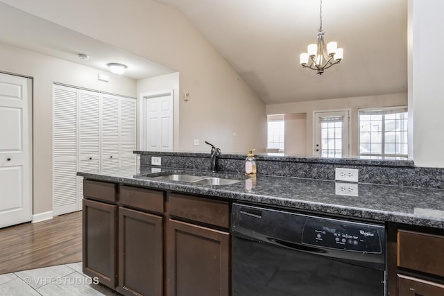 kitchen with vaulted ceiling, sink, dark stone countertops, dishwasher, and a chandelier