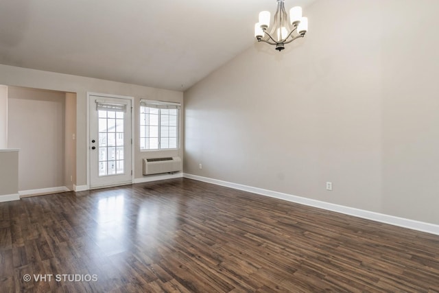 unfurnished room featuring a chandelier, an AC wall unit, dark wood-type flooring, and vaulted ceiling