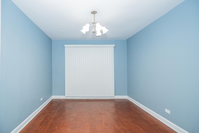 empty room with parquet flooring and an inviting chandelier