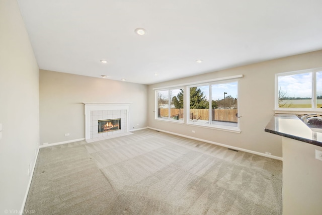 unfurnished living room with light carpet and a fireplace