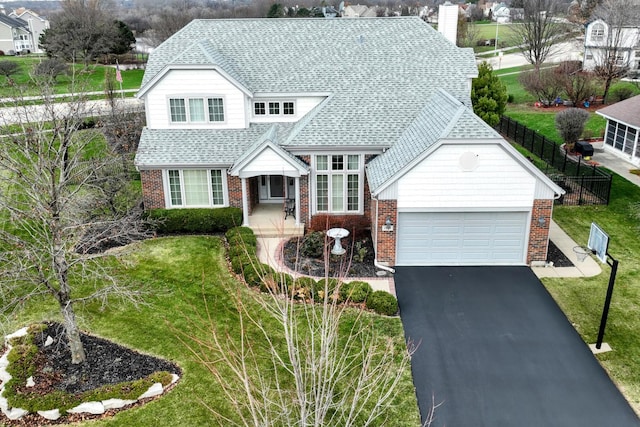 view of front of house with a porch, a garage, and a front lawn