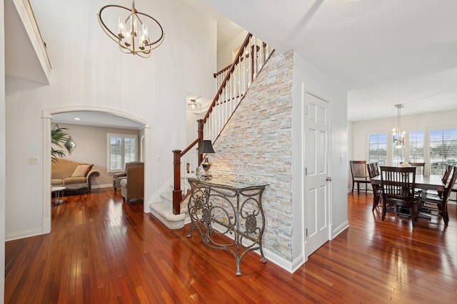 entrance foyer featuring a high ceiling, wood-type flooring, and a notable chandelier