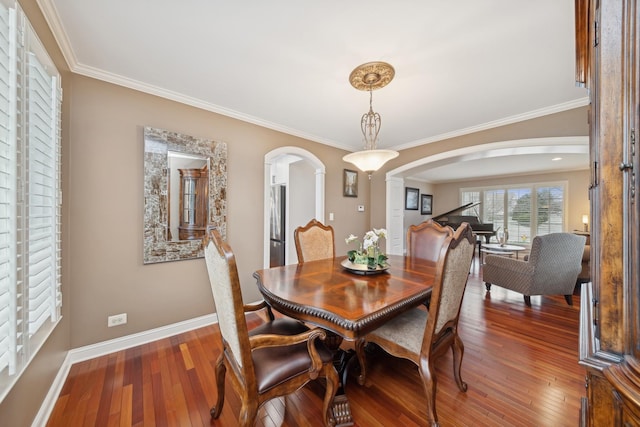 dining area with crown molding, dark wood-type flooring, and decorative columns