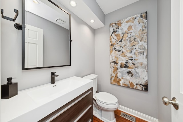 bathroom featuring hardwood / wood-style flooring, vanity, and toilet