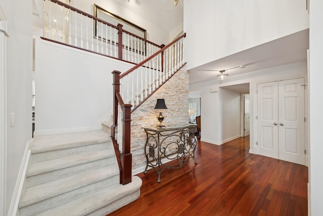 stairway featuring hardwood / wood-style floors and a towering ceiling