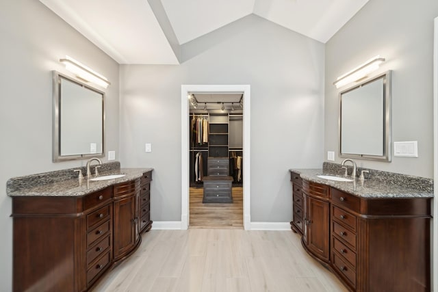 bathroom with vanity, vaulted ceiling, and hardwood / wood-style floors