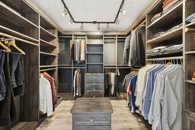 walk in closet with light hardwood / wood-style flooring