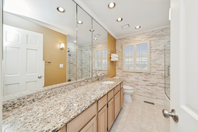 bathroom featuring a shower with door, crown molding, vanity, and toilet