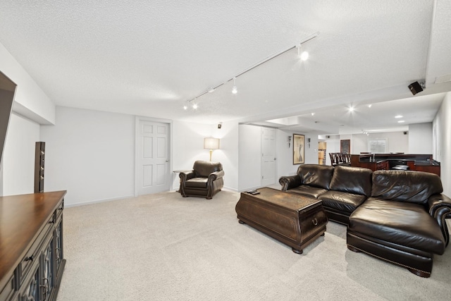 carpeted living room with rail lighting and a textured ceiling