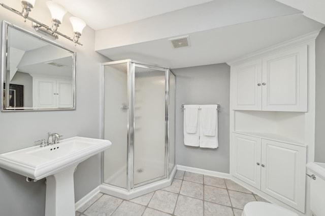 bathroom with sink, a shower with shower door, tile patterned floors, and toilet