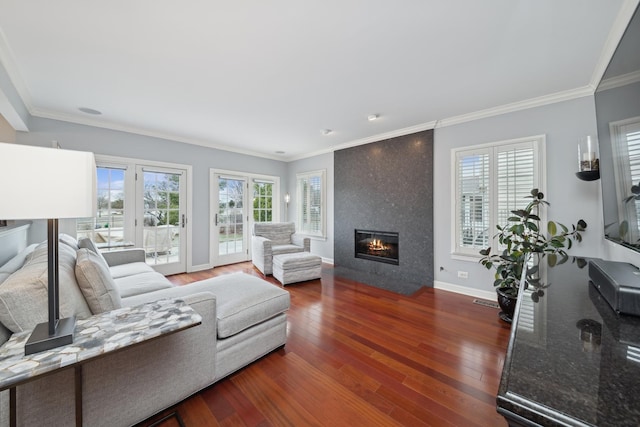 living room with crown molding, dark hardwood / wood-style flooring, and a tile fireplace