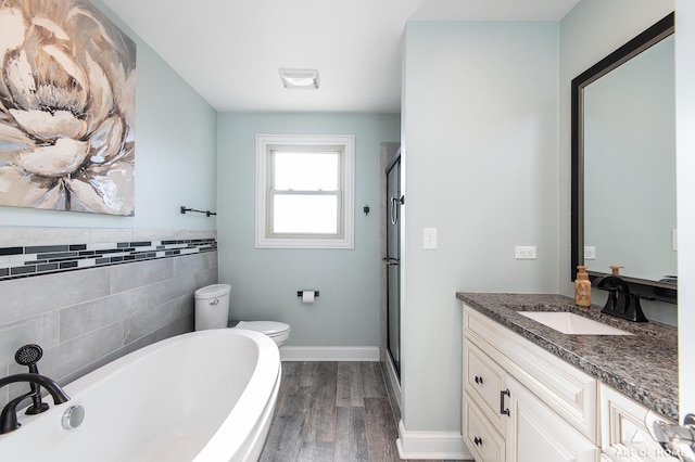 full bathroom featuring vanity, hardwood / wood-style flooring, toilet, tile walls, and independent shower and bath